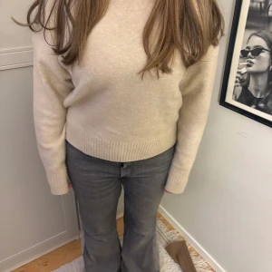 Beige stickad tröja - Säljer en mysig beige stickad tröja med långa ärmar och ribbade muddar vid ärmslut och där nere. Har tyvärr int använt med den är super fin