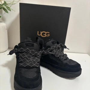 UGG lowmel - Snygga svarta sneakers från UGG med snörning och en robust sula. Perfekta för en stilren look. Skorna har en kombination av mocka och syntetmaterial för extra komfort och hållbarhet.