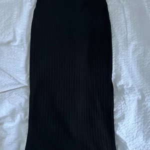 Svart kjol  - Snygg svart, ribbad, lång kjol från Gina Tricot i storlek M . Kjolen är strechtig och har en slits. Använd fåtal gånger och inga defekter!💘