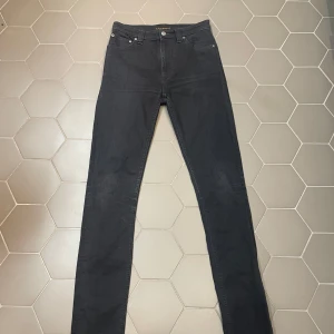 Svarta Nudie Jeans - Snygga svarta jeans från Nudie Jeans med en klassisk femficksdesign. De har en slim passform och är tillverkade i ett slitstarkt material. Perfekta för en stilren look.