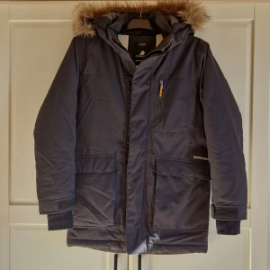 Jacka - Jacka i parkasmodell till barn. Avtagbar luva och pälskrage. Ganska stor i storlek. Vattentät och vinterfordrad. Rak modell. Mycket fint skick