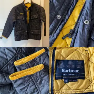 Superfin och äkta unisex Barbour jacka i nyskick. Från rökfritt och djurfritt hem. Storlek 8-11 år.  Svart med orangegult foder. Köpt på Kidsbrandstore. Nypris 1300:- säljes för 350:-