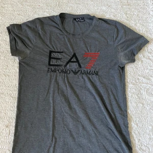 Grå Emporio Armani T-shirt  - Grå Emporia Arminia T-shirt i storlek s  Den är i nytt skick o säljs för jag växt ur den 