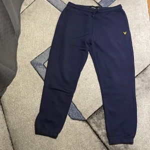 Mörkblå mjukisbyxor från Lyle & Scott - Säljer ett par mörkblå mjukisbyxor från Lyle & Scott. De är superbekväma med elastisk midja och snörning för perfekt passform. Knappt använda då jag använder andra kläder så säljer de. Storlek L men passar också M