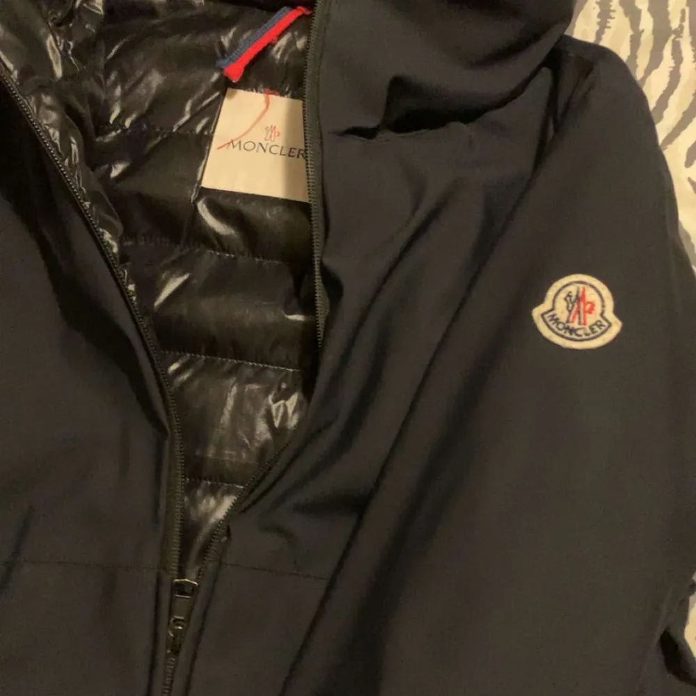 Säljer en snygg svart jacka från Moncler. Den har en stilren design med dragkedja och Moncler-logga på ärmen. Jackan är perfekt för kyligare väder och har en quiltad insida för extra värme. Passar både till vardags och fest!. Jackor.