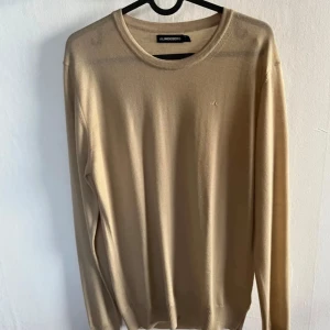 J.Lindeberg  -  Nu kan du göra ett riktigt kap! En väldigt fin tröja ifrån J.Lindeberg som är känd för sin stilrena design och kvalitet. Denna tröja är i strl M och har inga tecken på användning. Köpt för en månad sedan och använd en gång. Färgen är beige.  