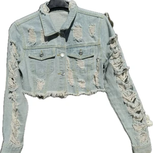 Ljusblå croppad jeansjacka med slitningar - Säljer en ljusblå xxs  croppad jeansjacka med massor av slitningar för en edgy look. Jackan har långa ärmar och knappar framtill. Hämtas på Hägerstensåsen eller ök 💙