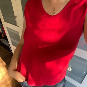 Rött linne - Säljer ett snyggt vintage rött linne från Ze-Ze. I fint skick med fina pärldetaljer framtill. 