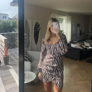 Zebraklänning - Säljer denna coola Zebraklänningen i brunt och vitt från NA-KD. Använd på en festival en gång. Storlek S🤎🤍
