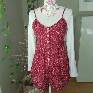 Blommig romper med knäppning - Oanvänd! Små"prasslig" polyester, passar S/M. Tröjan ingår ej! ~ STOR rensning & klänningsbonanza i min shop ~ Välj 5 för 100kr oavsett pris, skicka medd/lämna som prisförslag (gäller där det står) ~