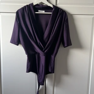 Lila omlottopp från Pieces i storlek M. - Snygg lila omlottopp från Pieces med trekvartsärm. Väldigt elegant och festlig topp som man kan använda vid olika tillfällen. Sitter som en smeck!!!❣️