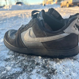 Svarta Nike sneakers - (Pris kan diskuteras vid snabb affär) Snygga svarta Nike sneakers med grå detaljer och klassisk snörning. Perfekta för vardagsbruk med en stilren design och bekväm passform.
