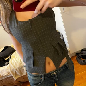 Grå randig korsettväst - Snygg grå korsettväst med smala ränder öppen i ryggen 