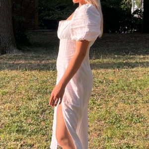 Vit Linneklänning Na-kd - Vadlång med slits. Materialet är 100% linne, puffiga ärmar. Från Na-Kd. Köpt för 699kr. Storlek 38, men den är rymlig. 