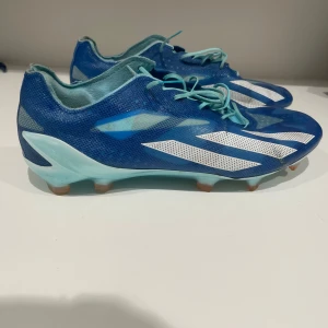 Adidas x Crazyfast + - Snygga blåa fotbollsskor från adidas i storlek 40   ( passar mig som brukar ha 40,5-41) skorna är knappt använda då jag har haft andra skor under säsongen . skorna är avsedda för naturgräs men ska funka även på konstgräs. Otroligt sköna och lätta då dem endast väger 175 gram! 