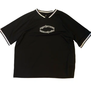 Svart t-shirt från H&M med tryck - Snygg svart t-shirt från H&M med texten 'togetherness' tryckt på framsidan. T-shirten har vita detaljer vid hals och ärmslut och är i en oversized passform. Jag har inte använt den något mycket men säljer då det inte är min stil längre. Storleken är XXL men passar även som XL och L (i oversized passform då)