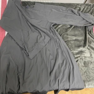 Grå abaya  - Säljer en stilren grå abaya med långärmad design. Perfekt för en elegant och avslappnad look. Klänningen har en enkel och tidlös stil som passar många tillfällen.