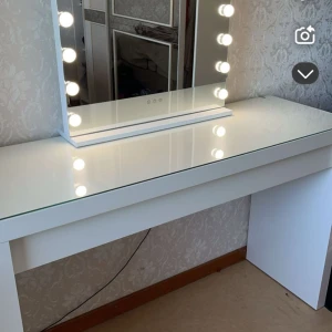 Vit sminkspegel med belysning - Elegant vit sminkspegel med inbyggd belysning runt kanterna. Perfekt för att få till den rätta makeupen med jämn belysning. Spegeln står på ett stilrent vitt bord med glasskiva, vilket ger en modern och lyxig känsla. Det finns 3 olika belysningsfärger, och ljustyrkan på lamporna kan justeras. 