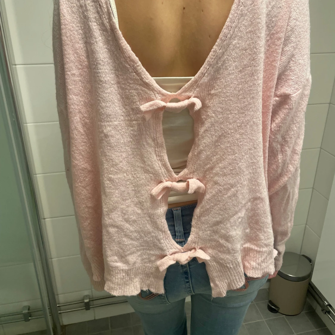 Rosa tröja med öppen rygg med rosetter