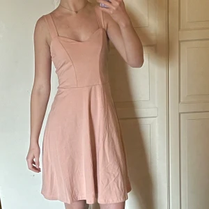 Rosa klänning från Pieces - Säljer en stilren rosa klänning från Pieces i storlek XS. Klänningen har en vacker passform med breda axelband och en lätt utställd kjol. Perfekt för sommaren! I verkligheten är klänningen rosa💕