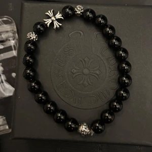Svart Pärlarmband HELT NY - Snyggt svart pärlarmband med svarta pärlor och detaljer. Armbandet har en cool korsdetalj som ger det en unik stil. Perfekt för att användas varje dag! Skriv vid frågor och funderingar ;D 😎
