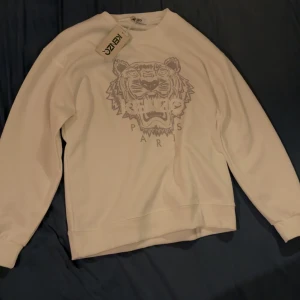 Vit sweatshirt från Kenzo med tigertryck - Säljer en stilren vit sweatshirt från Kenzo med ett  tigertryck på framsidan.                                    Storlek: L