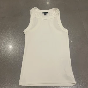 Vit ribbad linnetopp från New Yorker  - Säljer en stilren vit ribbad linnetopp från New Yorker. Med en ärmlös design och mjuk material. Aldrig använd. Skriv privat för fler bilder eller frågor :) 