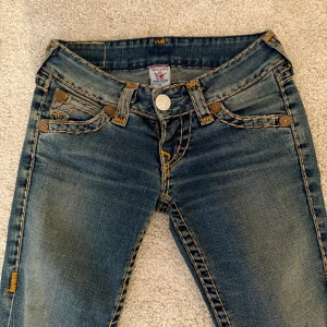 Blå jeans från True Religion - Snygga blå jeans från True Religion. De är lågmidjade med en rak/boot cut passform. Bra skick förutom en liten slitning vid badfickan som inte syns. 