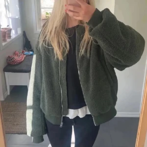 Grön teddyjacka från COS - ( lånade bilder) Säljer en supermysig grön teddyjacka från COS. Den har en dragkedja framtill och långa ärmar. Perfekt för höst och vinter, helt ny och oanvänd