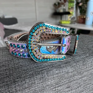 Tuttolente bälte - Säljer mitt tuttolente skärp. Använt några gånger. Mycket fint skick. Men den har förlorat någon sten. Den förra ägaren hade gjort ett extra hål i bältet, se sista bilden. Ser ut som ett BB bälte. 100cm långt. Skriv om du har frågor eller fler bilder