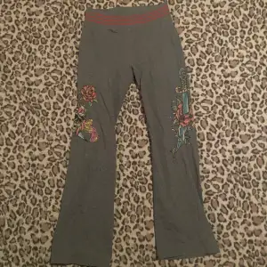 Säljer ett par grå byxor från Ed Hardy. Står att de är XL men passar som S. De har märket broderat i rött på baksidan och ena benet. Byxorna har en bekväm passform med elastisk midja och är perfekta för en avslappnad stil.