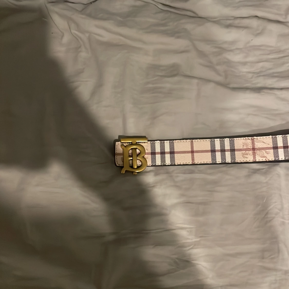 Rutig och svart bälte med guldfärgat spänne