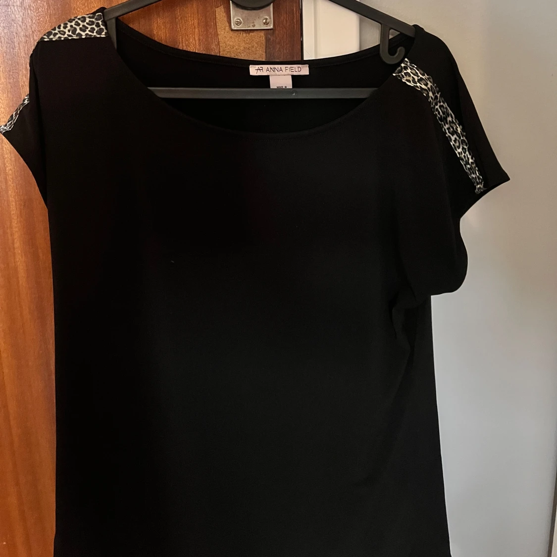 Svart t shirt som har en liten rand leopardmönster på axeln på varsin sida! - 91