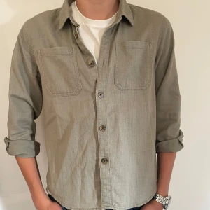 Grön overshirt skjorta - Grön skjorta i stl EU 158 UK 12-13Y men passar även på mig som är 180cm 14Y. Gjord på 100% bomull och är mjuk och skön. 