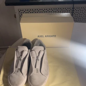 Axel Arigato skor - Säljer ett par feta Arigato skor i storleken 41💛Nypris är 2500kr Mitt pris 999kr🔥priset är inte hugget i sten. Skicket skulle jag säga är 8/10 lite smuts fläckar som går att ta bort💛kontakta för funderingar eller bilder😊💛(Allt OG ingår)