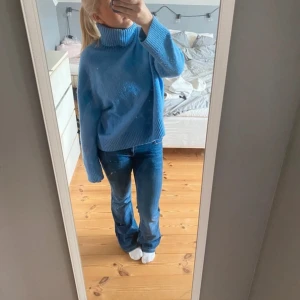 Blå stickad polotröja - Säljer en supermysig blå stickad polotröja. Den har en hög krage och långa ärmar, perfekt för kyliga dagar. Tröjan är i bra skick och passar perfekt till jeans för en avslappnad look. Perfekt för höst och vinter!