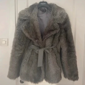 Grå pälsjacka - Supermysig grå pälsjacka med bälte i midjan. Den är i super fint skick i storlek S men kan också passa XS! 🩶
