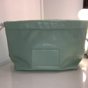 Caia necessär - En superfin grön necessär från Caia, den säljs inte längre, i bra skick. Se bild 3 för insidan, bra förvaring och lätt att ta med sig. Måtten är brädd: 32cm djup: 8cm och höjd 20cm. Den är stor och man få plats med mycket❤️