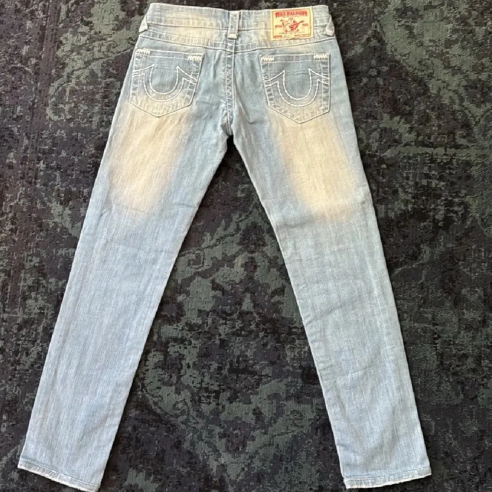 Säljer nu dessa snygga jeans i färgen ljusblå, från märket True Religion.  De är i mycket fint skick, och använts vid endast 2 tillfällen! Stl: W27 Skick: 9/10 Mått: Midja: 37cm innerbensmått: 72cm ytterbensmått: 90cm Dm: Vid frågor eller funderingar:). Jeans & Byxor.