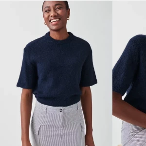 Mörkblå stickad tröja - Säljer en superfin mörkblå stickad tröja med korta ärmar. Perfekt för både vår och höst! Den har en enkel och stilren design som passar till det mesta. Tröjan är i mycket bra skick och känns riktigt skön att ha på sig. Perfekt för en casual look eller att klä upp med accessoarer. 💙