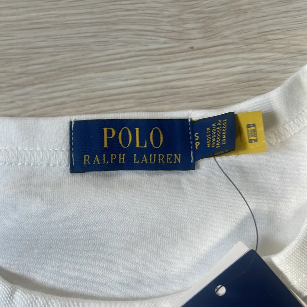 Säljer en stilren vit tröja från Polo Ralph Lauren i nytt skick. Tröjan har en klassisk design med långärmade ärmar och det ikoniska logotypbroderiet på bröstet. Perfekt för både vardag och festliga tillfällen. Passar bra till jeans eller chinos för en avslappnad men ändå elegant look.. Tröjor & Koftor.