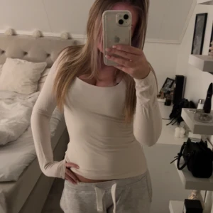 Vit långärmad topp - Säljer en superfin vit långärmad topp i mycket bra skick. Den är tight och perfekt för både vardag och fest. Toppen är gjord i ett mjukt och stretchigt material som sitter skönt på kroppen. 