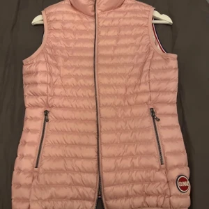 Rosa dunväst från Colmar - Säljer en superfin rosa dunväst från Colmar i storlek 14y166cm/XS. Västen har en dragkedja framtill och två fickor med dragkedjor. 