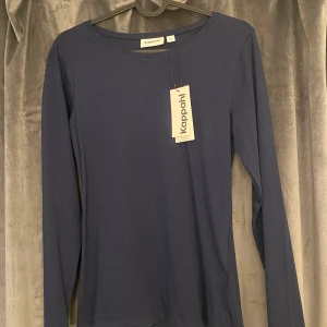 Mörkblå långärmad tröja från Kappahl - Säljer helt ny mörkblå tajt långärmad tröja från Kappahl, alldrig använd lappen finns kvar. Köpte för 200kr och säljer för en mycket mängd mindre för vill bara bli av med den. Tänk på att kolla flera av mina plagg! om ni köper flera kommer ni kunna få extremt mycket rabatt!!!!