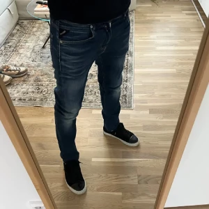 Mörkblå jeans från Replay - Snygga mörkblå jeansbyxor från Replay med en slim passform. Byxorna har en klassisk femficksdesign och är tillverkade i ett slitstarkt denimtyg. Perfekta för en stilren look.