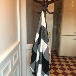 Svartvit rutig halsduk - Snygg och stilren svartvit halsduk med rutigt mönster. Perfekt för att hålla sig varm under kyliga dagar. Den har en klassisk design som passar till många olika outfits.