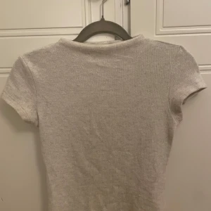 Beige ribbad topp från Pull&Bear(storlek s) - Säljer en stilren beige ribbad topp från Pull&Bear. Toppen har korta ärmar och en klassisk rund halsringning med ett mysigt material.