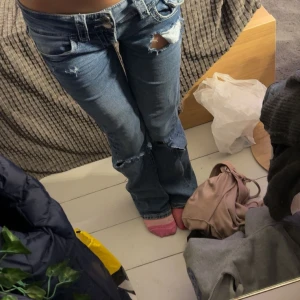 Blå jeans med slitningar - Snygga blå jeans med slitningar och bootcut-stil. De är lågmidjade!! säljer då jag inte använder de!!