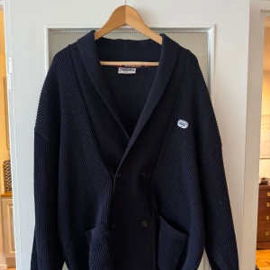 Marinblå kofta/cardigan från marine - Säljer en knappt använd cardigan från marine. Dubbelknäppt och ribbstickad. Ett litet hål på höger axel men som knappt syns när den bärs.