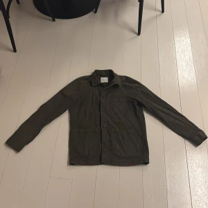 Mörkgrön overshirt  A Day's March - A Day’s March overshirt i medium blandning av oliv och militärgrön 